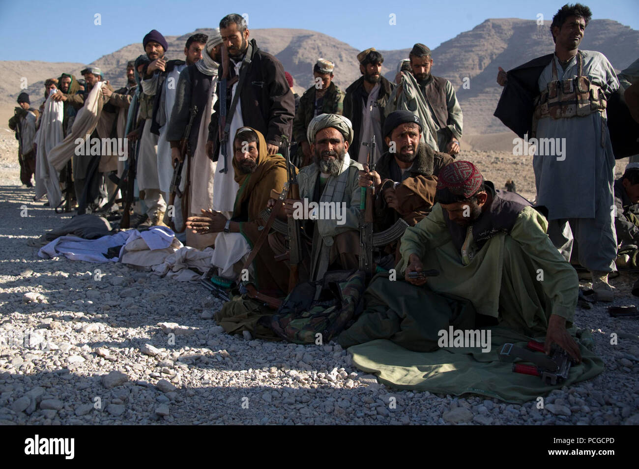 Afghan Polizia locale linea fino a raccogliere coperte e stufe in quartiere Kajran, Daykundi provincia, Afghanistan, dic. 29. Coalizione di forze per le operazioni speciali rilasciati gli elementi per ALP checkpoint in ordine per l'ALP per stare al caldo durante la stagione invernale. Foto Stock