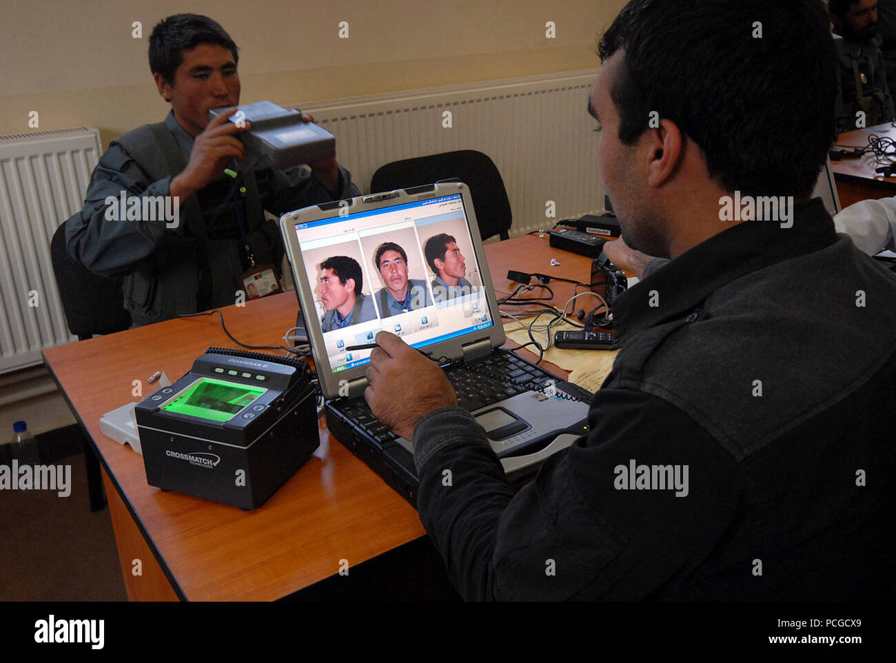KABUL, Afghanistan (18 aprile 2010) - Un membro della nazionale afghano di ordine civile di polizia (ANCOP), a sinistra è stata registrata utilizzando un advanced biometria sistema di registrazione presso un impianto di Kabul. I funzionari di polizia registrata e ha ricevuto i briefing e formazione che si preparano per le operazioni in Afghanistan. (US Navy Foto Stock