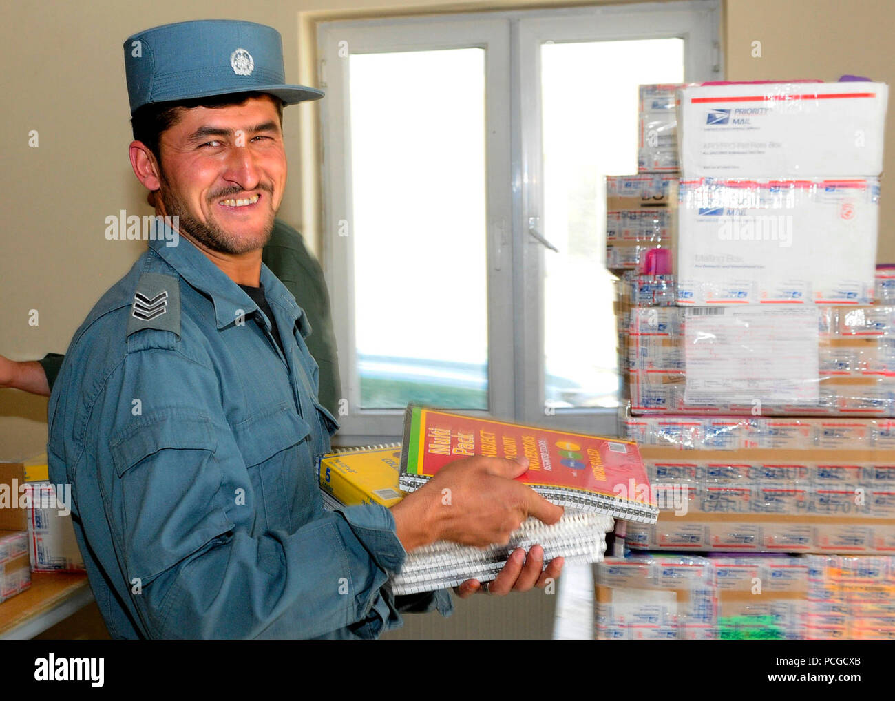 KABUL, Afghanistan - una nazionale afghano di ordine civile sergente di polizia aiuta a caricare le scatole di forniture scolastiche per essere distribuito in una scuola locale. Comando ANCOP Sgt. Il Mag. Abdul Wihad la punta di diamante della donazione di forniture scolastiche che ha luogo una volta al mese Foto Stock