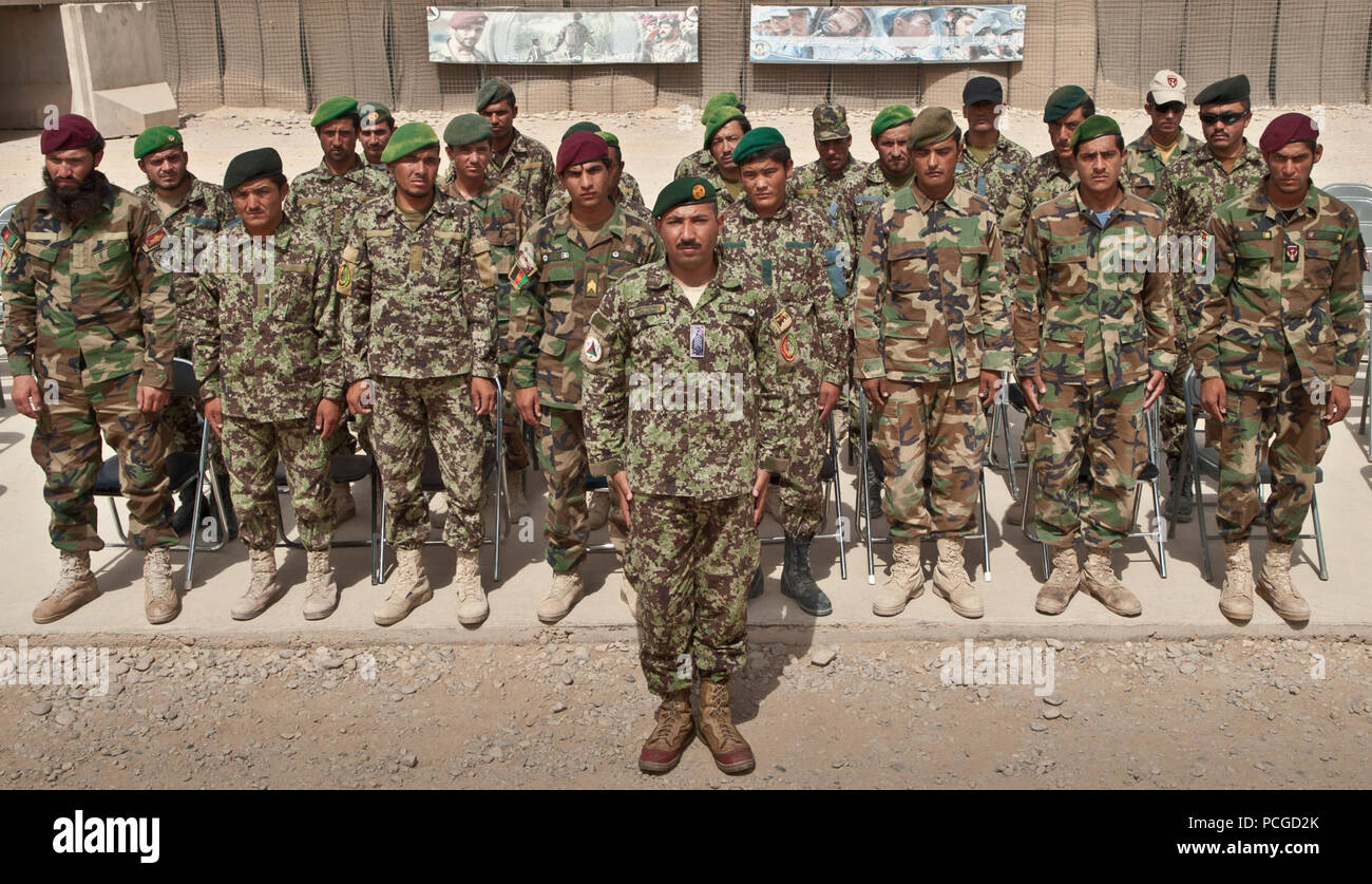 Nazionale Afghano di forza di sicurezza Classe di laurea di ventiquattro studenti stand durante una cerimonia di consegna dei diplomi per completare l'esplosivo pericolo corso di riduzione in corrispondenza della giunzione supporto Academy a sud-ovest a bordo di Camp Leatherneck, provincia di Helmand, luglio 14. Il corso insegna agli studenti come reagire quando incontrano ordigni esplosivi artigianali, le nozioni di base di insorti tattiche di IED e come gestire ed eliminare gli ordigni inesplosi e le munizioni. Foto Stock