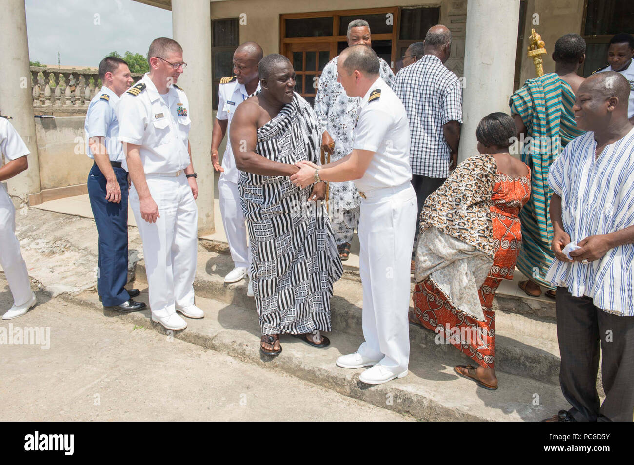 SEKONDI, Ghana (feb. 3, 2015) della Cmdr. Matteo Flemming di Virginia Beach, Virginia, centro-destra, Africa Partnership stazione comandante della missione a bordo i militari Sealift il comando congiunto del ad alta velocità a nave USNS Spearhead (JHSV 1), scuote le mani con un ghanese locale capo tribù, di centro-sinistra, Febbraio 3, 2015. Punta di diamante è su una distribuzione programmata per gli Stati Uniti Sesta flotta area di operazioni a sostegno della collaborazione internazionali di costruzione di capacità del programma di Partenariato Africa stazione. Foto Stock