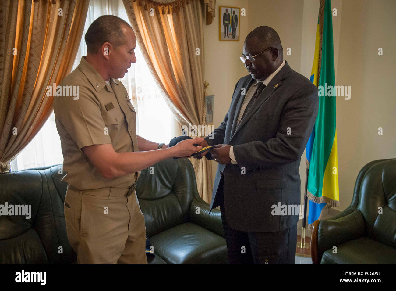 PORT Gentil, Gabon (7 aprile 2015) Africa Partnership stazione Comandante della Missione della Cmdr. Matteo Flemming presenta un tappo a sfera a Port Gentil Sindaco Aperano Bernard durante una visita di porta dai militari Sealift il comando congiunto del ad alta velocità a nave USNS Spearhead (JHSV 1) Aprile 7, 2015. Punta di diamante è su una distribuzione programmata per gli Stati Uniti Sesta flotta area di operazioni a sostegno della collaborazione internazionali di costruzione di capacità del programma di Partenariato Africa stazione. Foto Stock