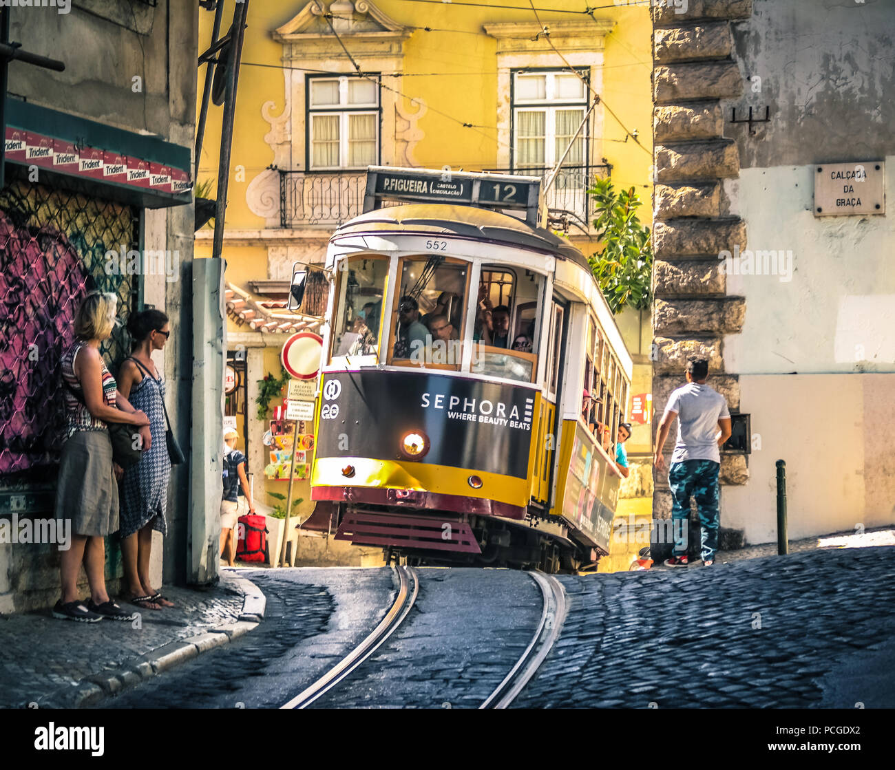 Storico tram 12 che sale su una ripida strada acciottolata fino a Travessa do Acógue, nel quartiere storico di Graa a Lisbona, Portogallo Foto Stock