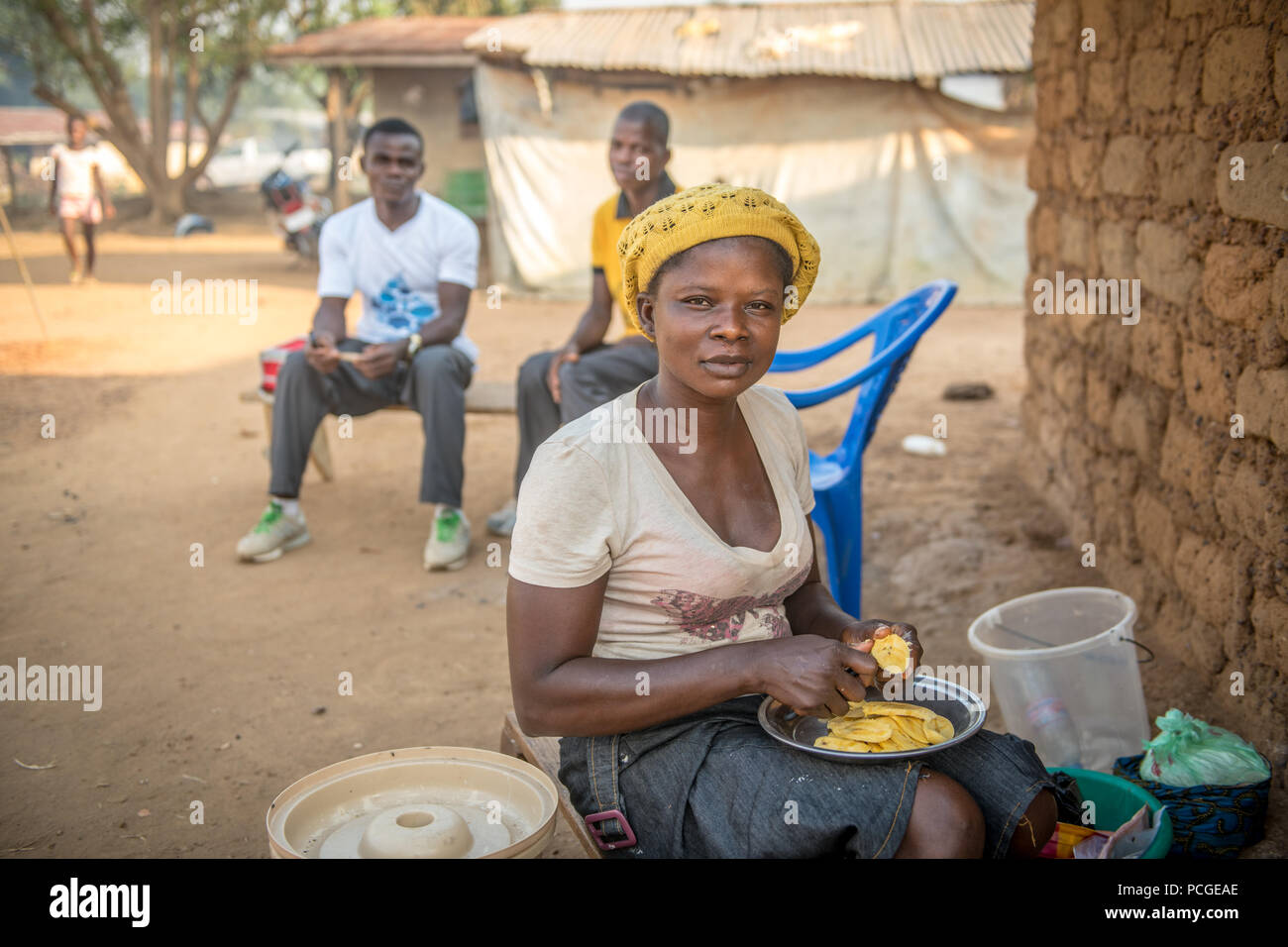 Una giovane donna taglia il cibo per un pasto in Ganta, Liberia Foto Stock