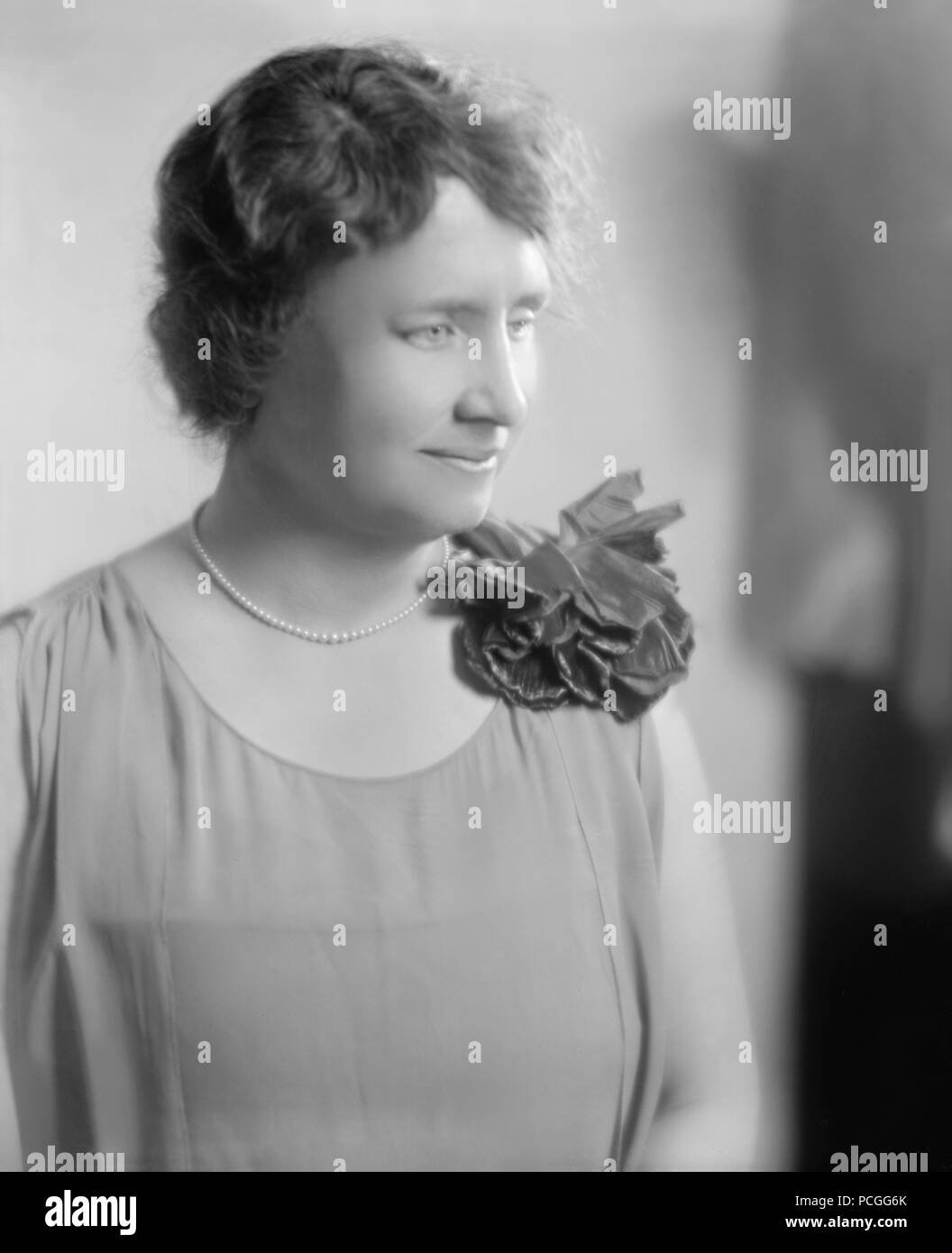 Helen Keller, seduti indossando un fiore e guardando verso sinistra in un ritratto non datata. Helen Keller (Giugno 27, 1880 - Giugno 1, 1968) era un autore americano, attivista politico, e docente. Lei è stato il primo sordo-persona cieca per guadagnare un bachelor del grado di arti. Foto Stock