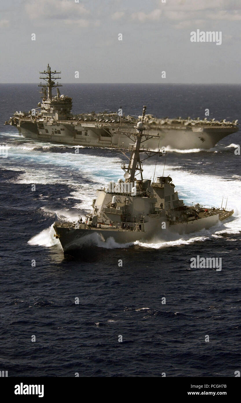 Dopo aver ricevuto migliaia di litri di carburante durante il rifornimento di carburante in mare, U.S. Navy Arleigh Burke Class Destroyer USS Paul Hamilton (DDG 60) tira chiaro della classe Nimitz portaerei USS Ronald Reagan (CVN 76). Il Ronald Reagan Carrier Strike gruppo è attualmente in corso a sostegno delle operazioni nel Pacifico occidentale. Foto Stock