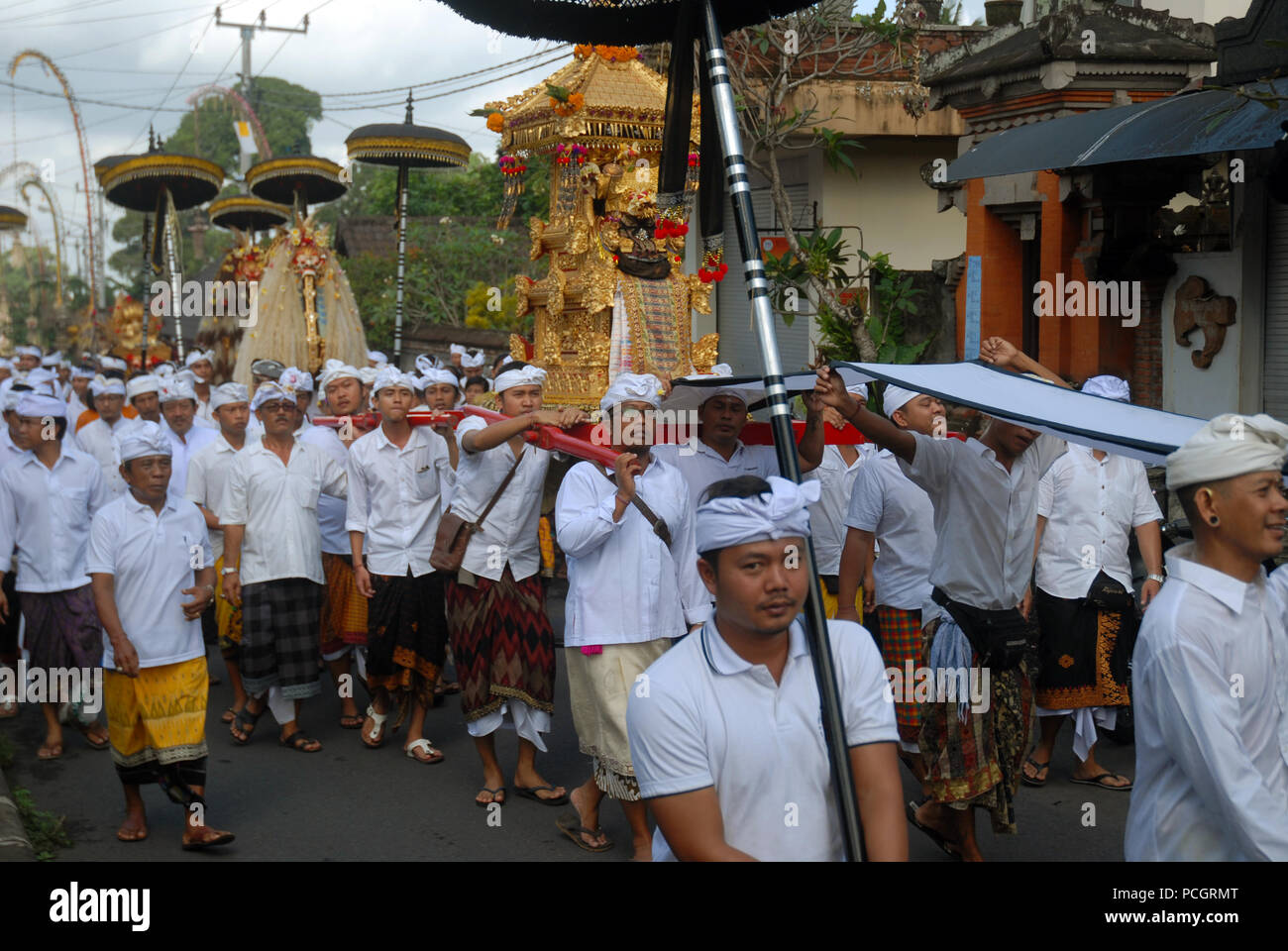 Un tempio indù processione, camminando attraverso le strade di Ubud, Bali, Indonesia. Foto Stock