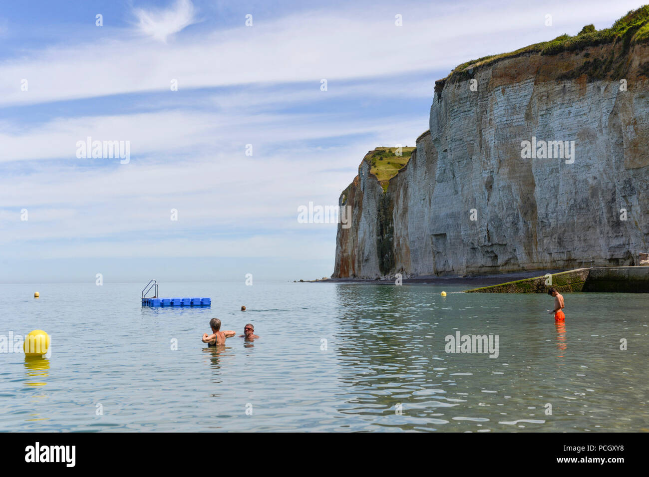 Saint-Pierre-en-Port (Normandia Francia settentrionale). Cote d'Alabastro (costa di alabastro). Chalk cliffs e nuotatori sulla spiaggia di ghiaia lungo il mare. Foto Stock