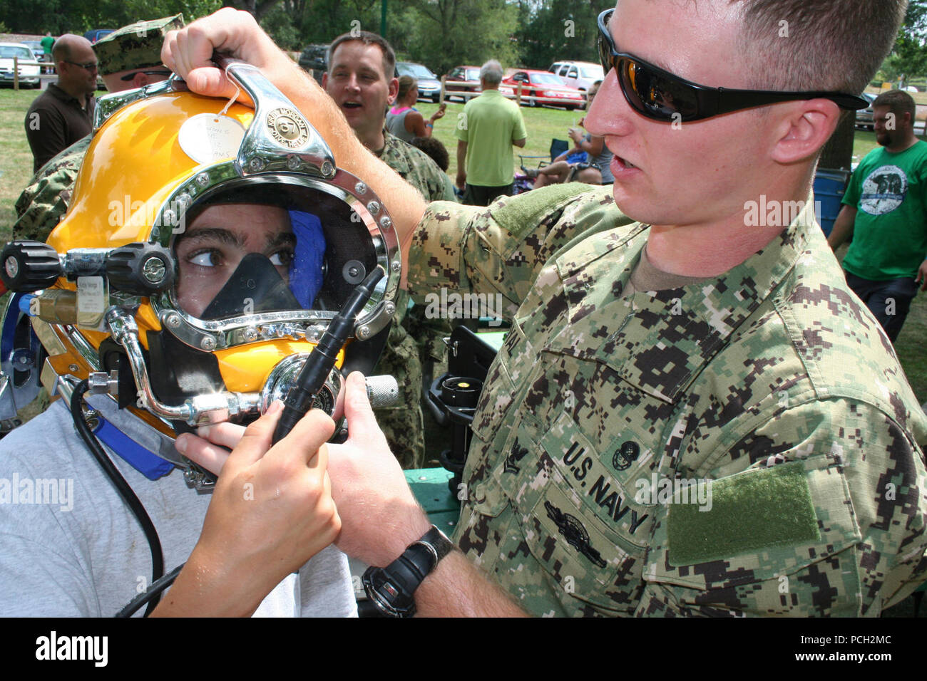 SIOUX FALLS, S.D. (21 luglio 2012) Navy Diver 2a classe Jordon Royal, assegnato a Mobile Diving e unità di soccorso (MDSU) 1, dimostra di attrezzature subacquee per un giovane volontario durante una comunicazione alla comunità evento con Consiglio Sioux Cub Scout durante Sioux Falls Navy Week 2012. Sioux Falls Settimana della Marina Militare è uno dei 15 Navy settimane previsto in tutta l'America per 2012. Navy settimane sono progettati per mostrare gli investimenti americani hanno fatto nella loro marina e aumentare la consapevolezza in città che non hanno una significativa presenza della Marina. Foto Stock