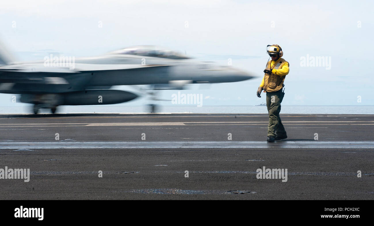 Sul mare del sud della Cina (GEN. 23, 2012) di aviazione di Boatswain Mate (manipolazione) 2a classe Roberto Andiarena controlla il tempo come un'F/A-18F Super Hornet dalla Black Aces di Strike Fighter Squadron (VFA) 41 lancia off il ponte di volo della Nimitz-class portaerei USS John C. Stennis (CVN 74). John C. Stennis è operante negli Stati Uniti 7 flotta area di responsabilità mentre su un sette mese di distribuzione. Foto Stock