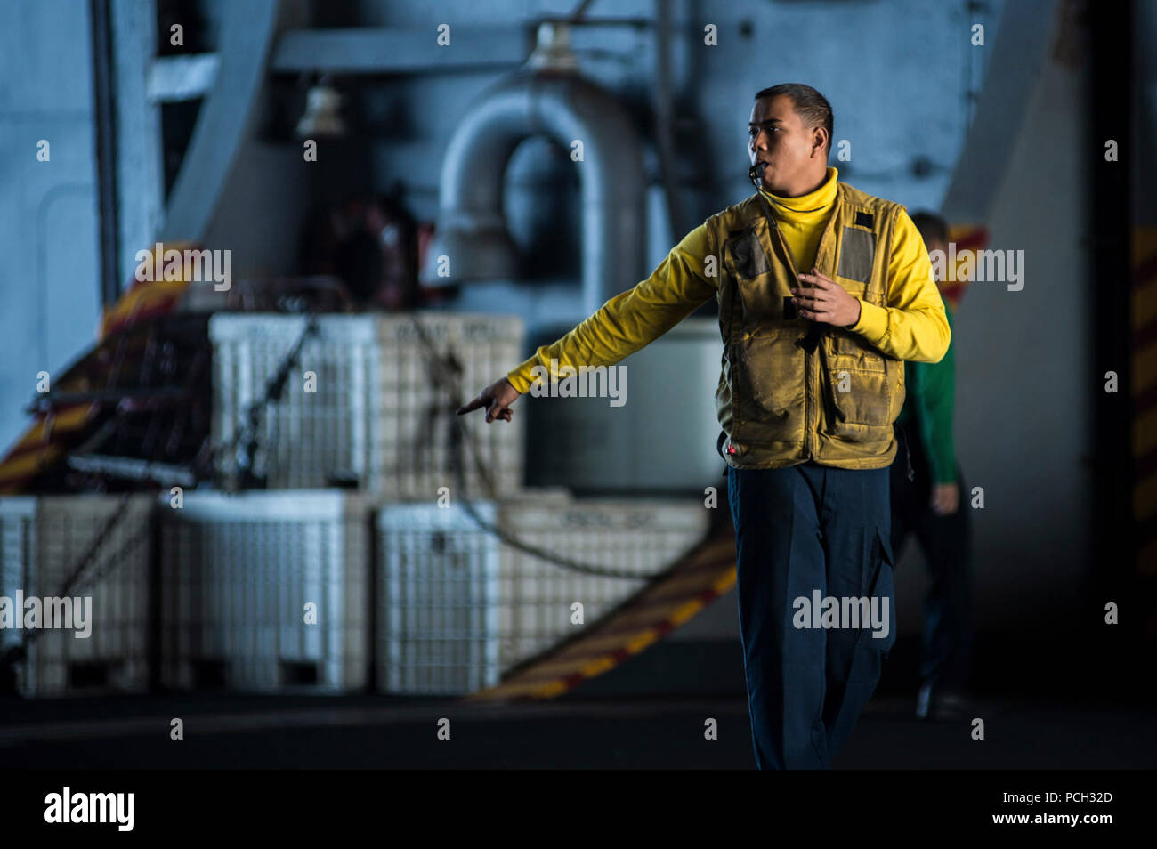 Oceano Pacifico (nov. 7, 2012) Aviation BoatswainХs Mate (manipolazione) 3° di classe Ron Pietro Magan guida il posizionamento di un velivolo ad ala fissa nell'hangar della portaerei USS Nimitz CVN (68). Nimitz è attualmente in corso che partecipano al shipХs joint task force esercizio (JTFEX). Foto Stock