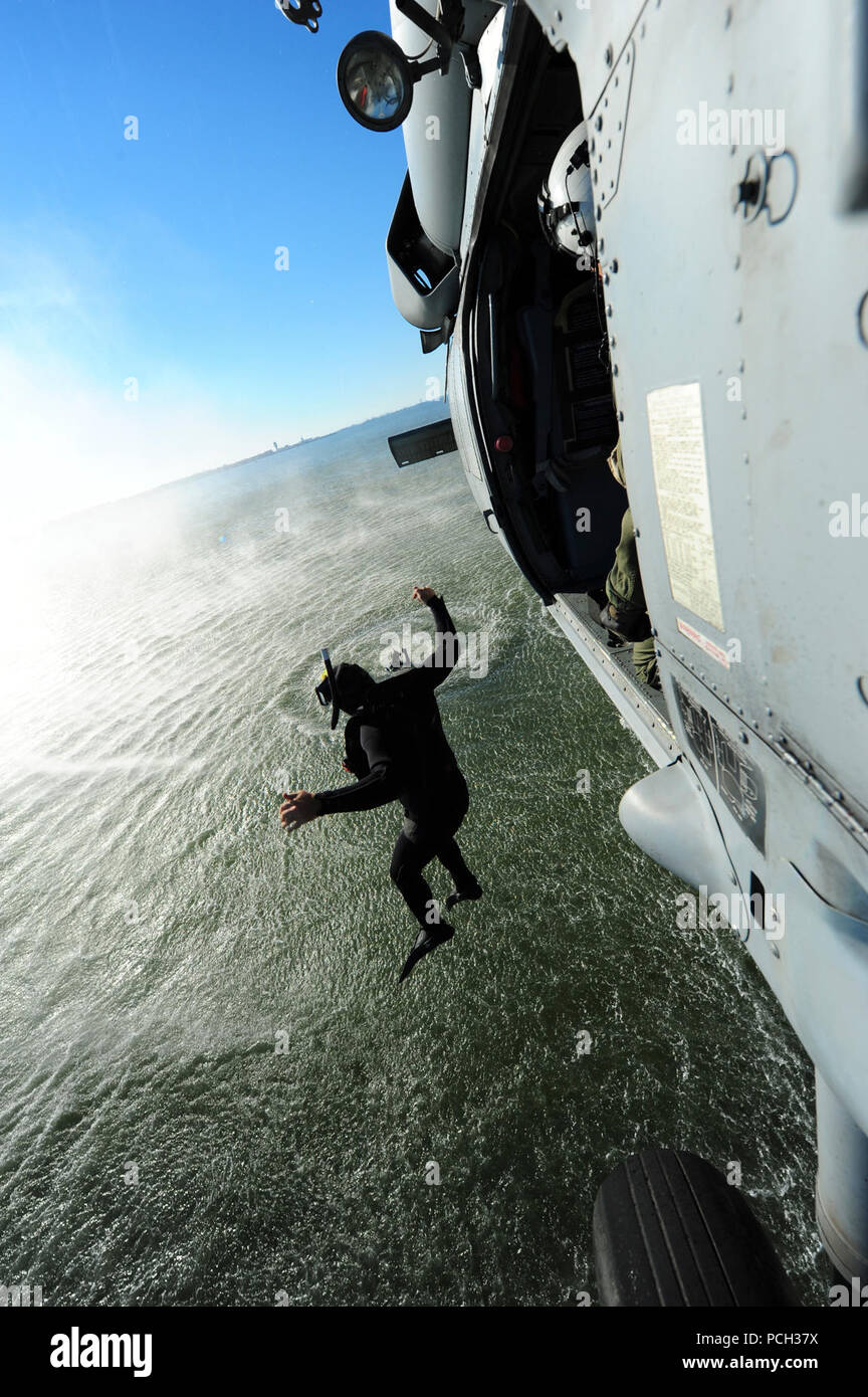 NORFOLK (ott. 22, 2012) un naval air crewman assegnato al mare in elicottero Combat Squadron (HSC) 9 salta da un MH-60S Sea Hawk elicottero durante la simulazione di operazioni di ricerca e salvataggio. Foto Stock