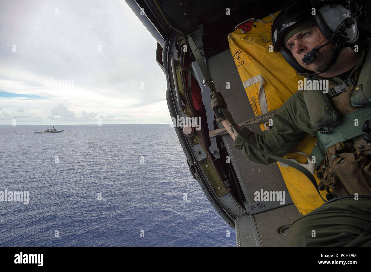 Mare delle Filippine (26 giugno 2016) Aircrewman navale (elicottero) 1a classe Justin Wright,da Linden, California, mans un paranco di salvataggio come suo elicottero vola oltre la Arleigh Burke-class guidato-missile destroyer USS Curtis Wilbur (DDG 54) durante un combattimento di ricerca e salvataggio di evoluzione della formazione a bordo di un MH-60S Sea Hawk elicottero assegnato al "falchi d'Oro" di elicottero di mare squadrone di combattimento (HCS) 12. HSC- 12 è imbarcata a bordo della USS Ronald Reagan (CVN 76) con Carrier aria Wing (CVW) 5 a sostegno della sicurezza e della stabilità in Indo-Asia-Pacifico. Foto Stock