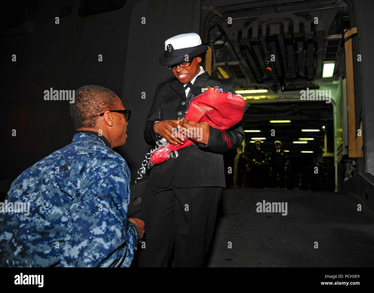 SASEBO, Giappone (dec. n. 3, 2012) Mineman 2a classe Damond Daley propone alla sua ragazza specialista culinaria 2a classe Andrenel Frazier dopo tre mesi di distribuzione a bordo di un assalto anfibio nave USS Bonhomme Richard (LHD 6). Bonhomme Richard è la nave di piombo del solo distribuita anfibio gruppo pronto ed è operante negli Stati Uniti 7 flotta area di responsabilità. Foto Stock
