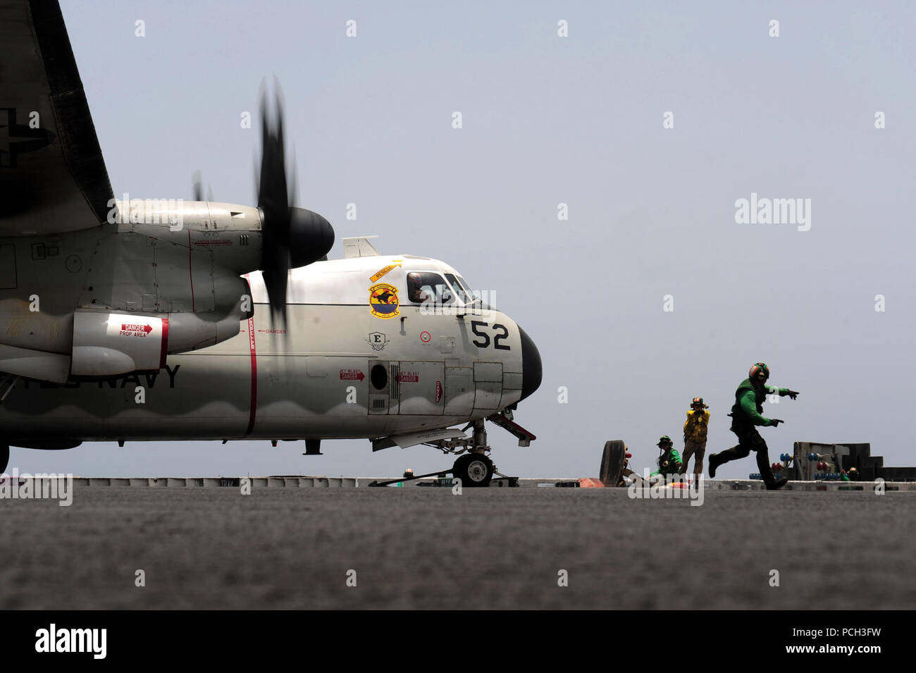 Mare (21 luglio 2012) un marinaio corre di sicurezza dopo una C-2un levriero assegnato all'Rawhides della flotta di supporto logistico Squadron (VRC) 40 è bloccata in posizione sulla catapulta durante le operazioni di volo a bordo della portaerei USS Enterprise (CVN 65). Enterprise è distribuito negli Stati Uniti Quinta Flotta area di responsabilità condurre le operazioni di sicurezza marittima, teatro la cooperazione in materia di sicurezza gli sforzi e le missioni di sostegno come parte dell'Operazione Enduring Freedom. Foto Stock