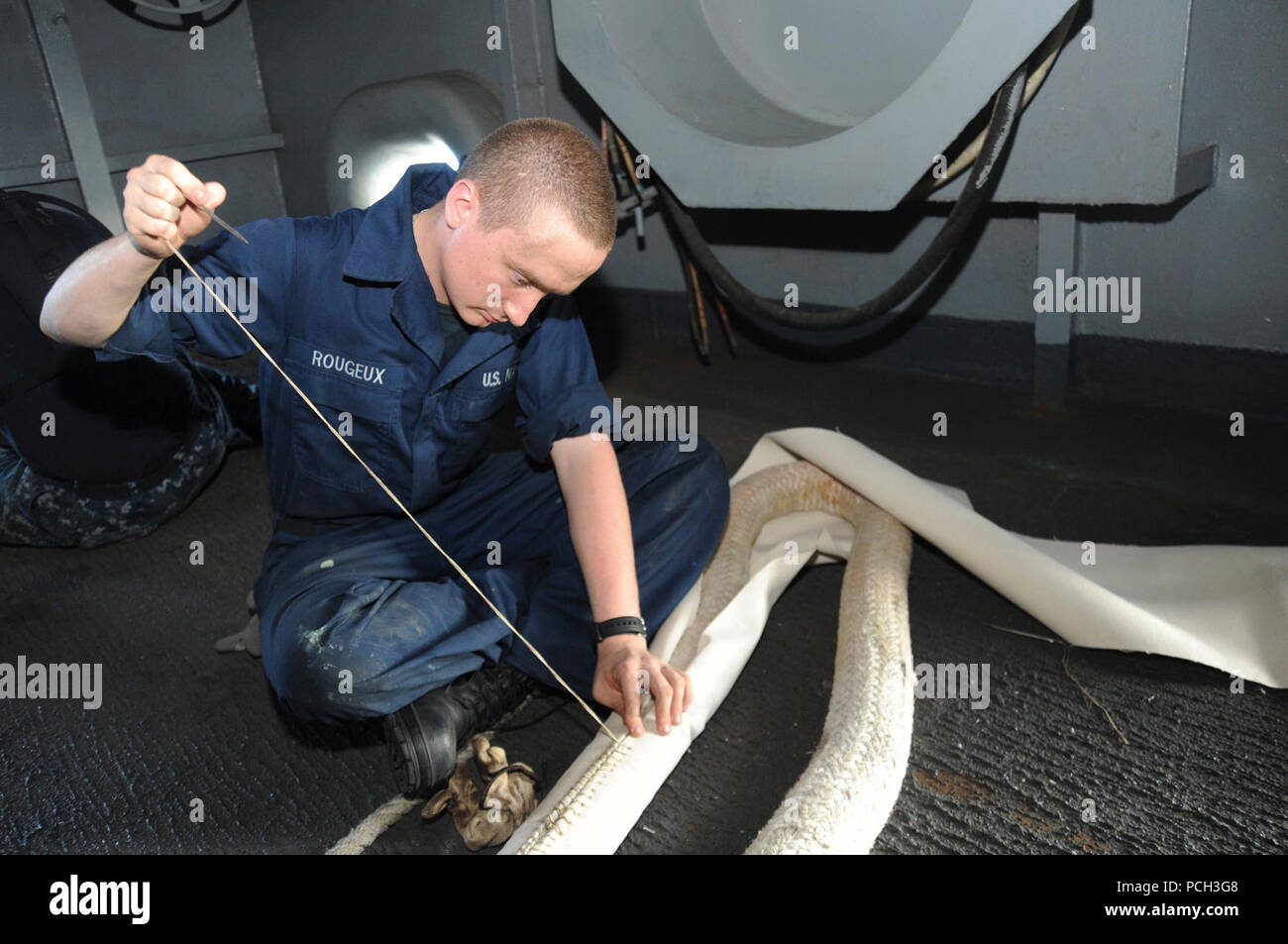 Mare Arabico (nov. 26, 2012) marinaio Andrew Rogeux cuce trinciature ingranaggio su una linea di ormeggio a bordo della Nimitz-class portaerei USS Dwight D. Eisenhower CVN (69). Dwight D. Eisenhower è distribuito negli Stati Uniti Quinta Flotta area di responsabilità condurre le operazioni di sicurezza marittima, teatro la cooperazione in materia di sicurezza gli sforzi e le missioni di sostegno come parte dell'Operazione Enduring Freedom. Foto Stock