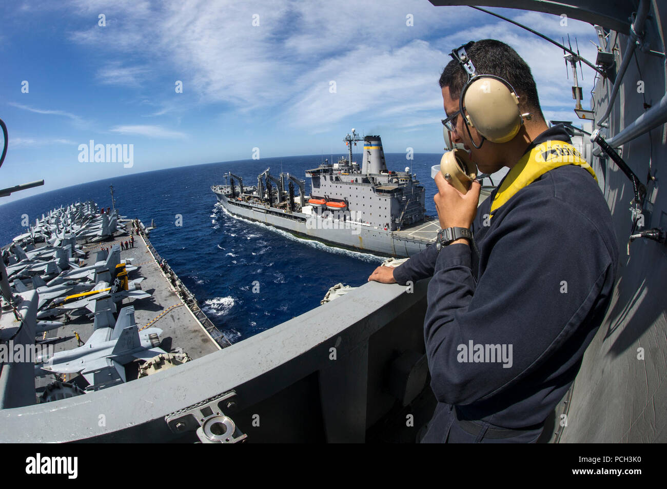 Mare delle Filippine (25 maggio 2015) marinaio Ricky Silva, da New Orleans, agisce come il belvedere di avanzamento durante un rifornimento in mare tra la Nimitz-class portaerei USS George Washington (CVN 73) e militari di comando Sealift flotta oliatore di rifornimento USNS Rappahannock (T-AO 204). George Washington e la sua aria imbarcato ala, Carrier aria Wing (CVW) 5, sono di pattuglia nel 7 ° Flotta area di responsabilità il supporto di sicurezza e stabilità nella Indo-Asia-regione del Pacifico. George Washington condurrà uno scafo-swap con la Nimitz-class portaerei USS Ronald Reagan (CVN 76) entro la fine di quest'anno Foto Stock