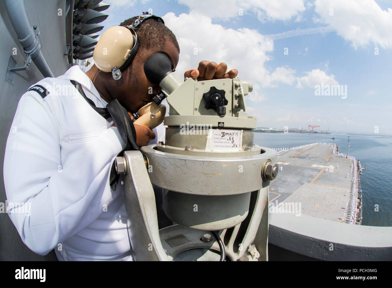 Baia di Tokio (18 maggio 2015) Quartermaster marinaio Ruben Jeanpierre, da New Orleans, utilizza un'alidada e sound-powered telefono come Nimitz-class portaerei USS George Washington CVN (73) si diparte per la sua pattuglia 2015. George Washington e la sua aria imbarcato ala, Carrier aria Wing (CVW) 5, fornire un contro-pronto forza che protegge e difende il collettivo agli interessi marittimi degli Stati Uniti e dei suoi alleati e partner in Indo-Asia-regione del Pacifico. Foto Stock