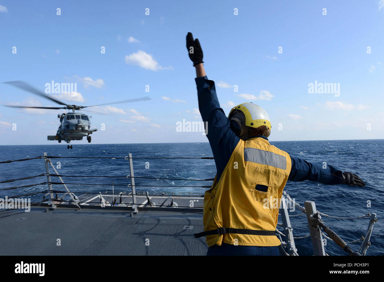 Oceano Pacifico (4 marzo 2013) Boatswain compagno del 3° di classe Brittany Chiles segnali per una SH-60B Mare Hawk elicottero mentre si atterra sul ponte di volo a bordo del Arleigh Burke-class guidato-missile destroyer USS McCampbell (DDG 85). McCampbell è parte del destroyer Squadron15, distribuito a Yokosuka, Giappone, ed è attualmente in corso di svolgimento esercizio puledro Eagle 2013 con nazione alleato per la Repubblica di Corea a sostegno della sicurezza regionale e la stabilità della regione Asia-Pacifico. Foto Stock