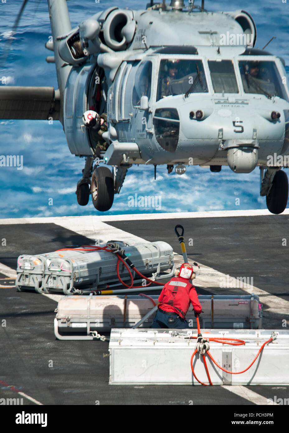 Oceano Pacifico (28 aprile 2013) un marinaio a bordo della portaerei USS Nimitz CVN (68) attribuisce al carico di un MH-60S Sea Hawk elicottero assegnato agli Indiani di elicottero di mare squadrone di combattimento (HSC) 6 durante la conduzione di un rifornimento in mare con la forza militare di comando Sealift carichi secchi e munizioni nave USNS Richard E. Byrd (T-AKE 4). Nimitz e Carrier aria Wing 11 sinistra San Diego per il Pacifico occidentale la distribuzione. Foto Stock