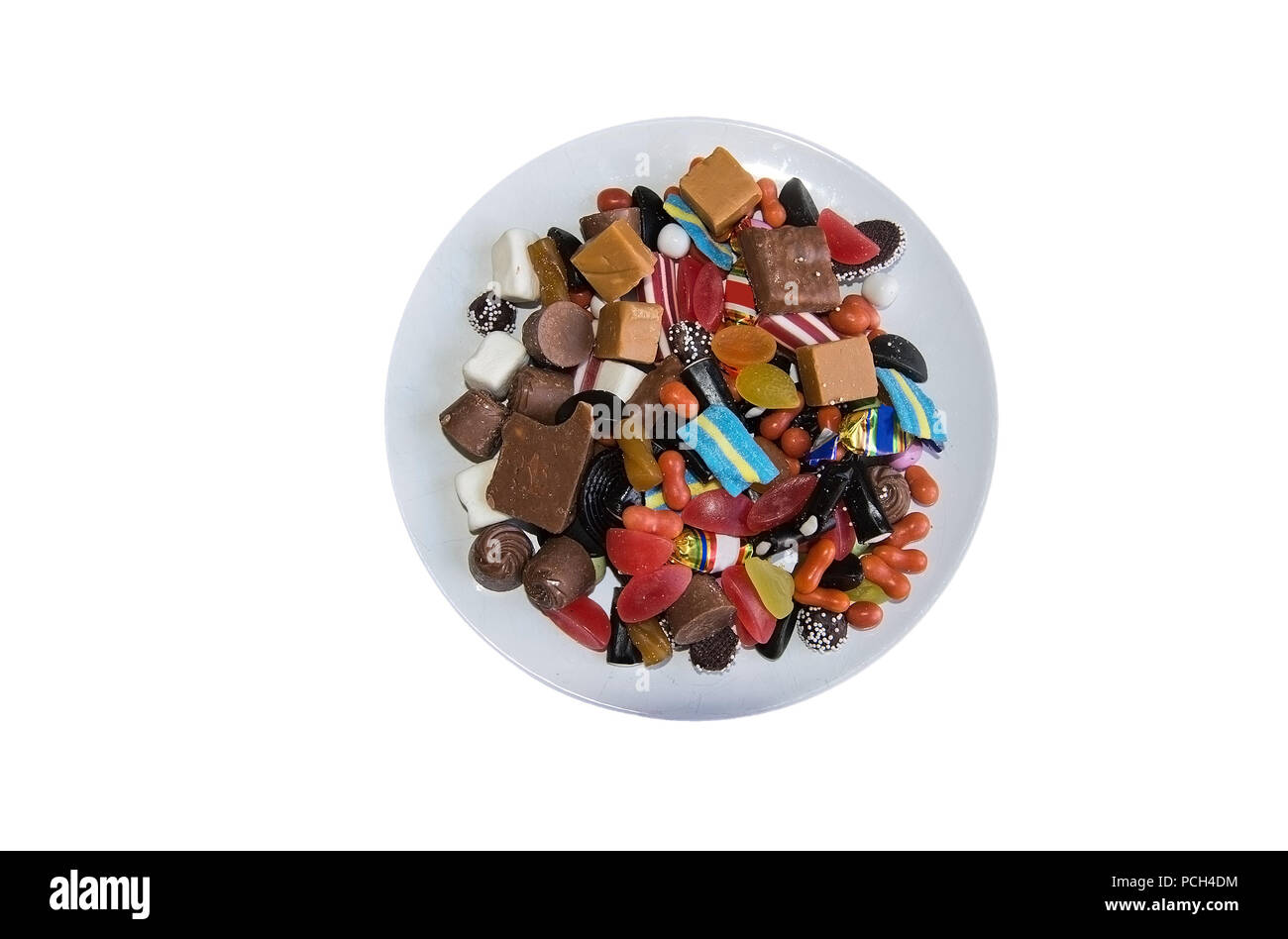 Cumulo di caramelle colorate sulla piastra bianca flatlay isolato su bianco Foto Stock