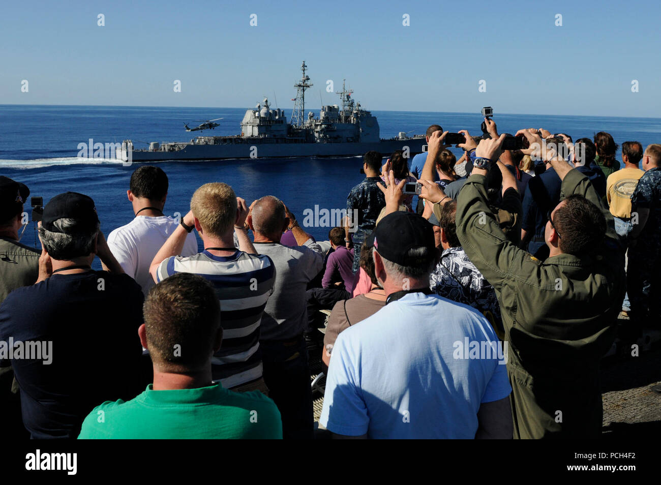 Tiger cruise i partecipanti guardano la Ticonderoga-class guidato-missili cruiser USS Bunker Hill (CG) 52 per il recupero di un elicottero durante un'aria di mare e dimostrazione di potenza sul ponte di volo a bordo della Nimitz-class portaerei USS Carl Vinson (CVN 70). Carl Vinson e Carrier aria Wing (CVW) 17 sono in corso su una crociera di tiger dopo il completamento di un progetto di distribuzione per gli Stati Uniti La quinta e la settima flotta zone di operazione. Foto Stock