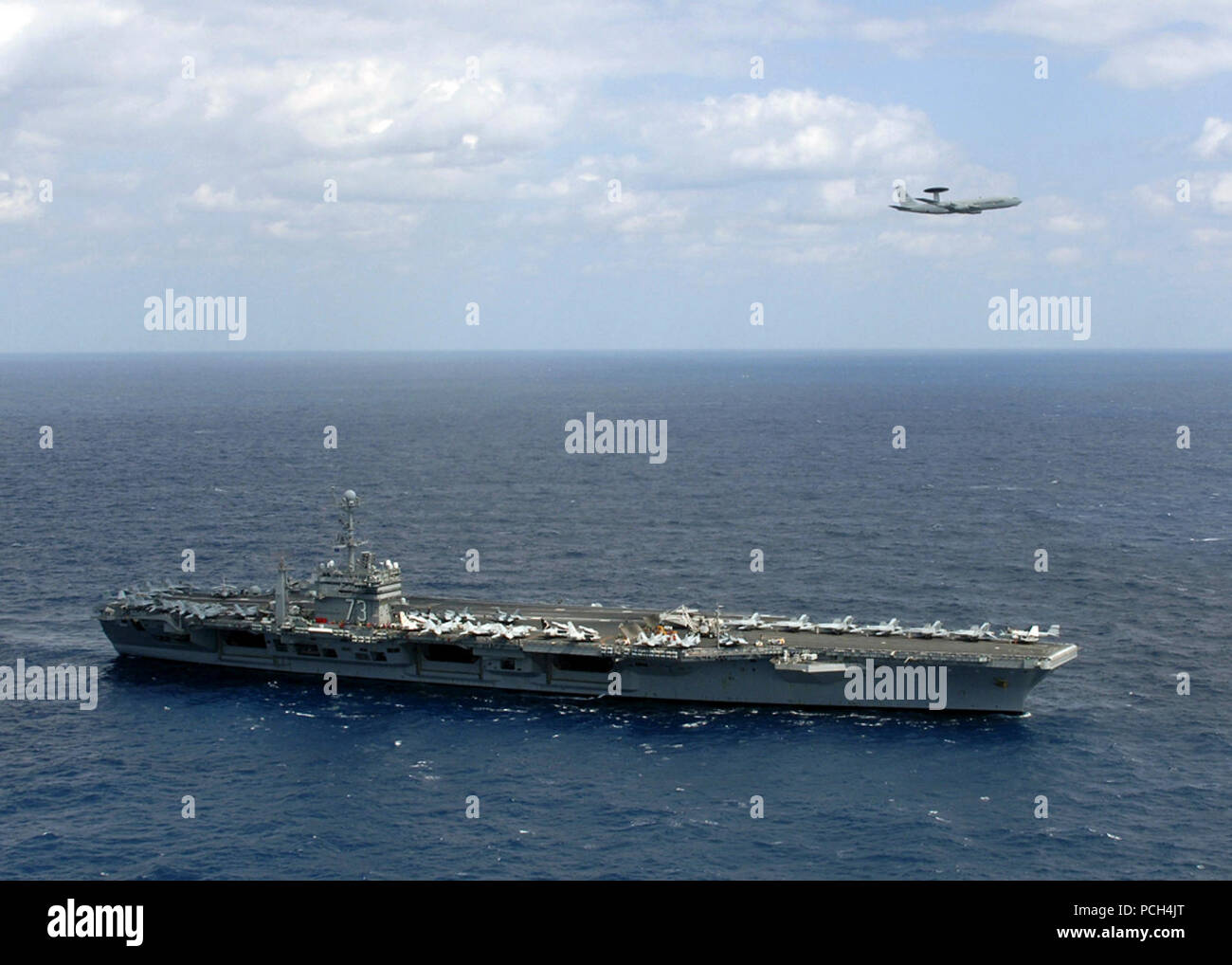 Una NATO E-3A Airborne Warning e sistema di controllo aereo sorvola la portaerei USS George Washington. George Washington sta partecipando in navi su misura la disponibilità di formazione e valutazione finale problema prima di un permanente cambiamento homeport a Yokosuka, Giappone. AWACS è utilizzato per fornire airborne battaglia la gestione, la sorveglianza e il controllo delle armi. Questa è la prima volta che un AWACS ha fatto un approccio basso volare da oltre un U.S. Naval nave. Foto Stock