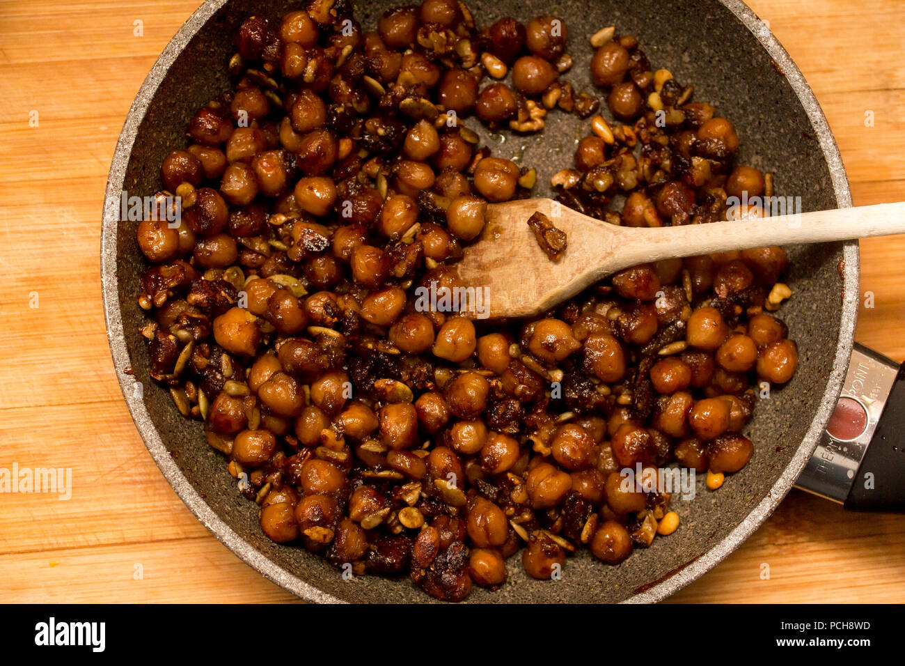 Serve una gustosa e croccante di ceci e semi di girasole in una padella per andare con insalata snack cibo di proteina Foto Stock