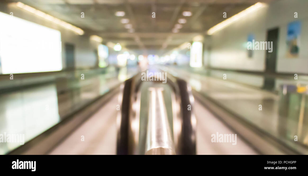 Uno sfondo sfocato di due passeggeri convogliatori a nastro di un aeroporto tedesco. Foto Stock