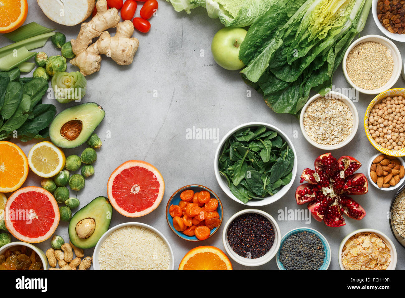 Piatto telaio laici di vegetariano cibo sano - diversi ortaggi e frutta, super, semi, cereali, verdura a foglia su sfondo bianco, vista dall'alto. C Foto Stock
