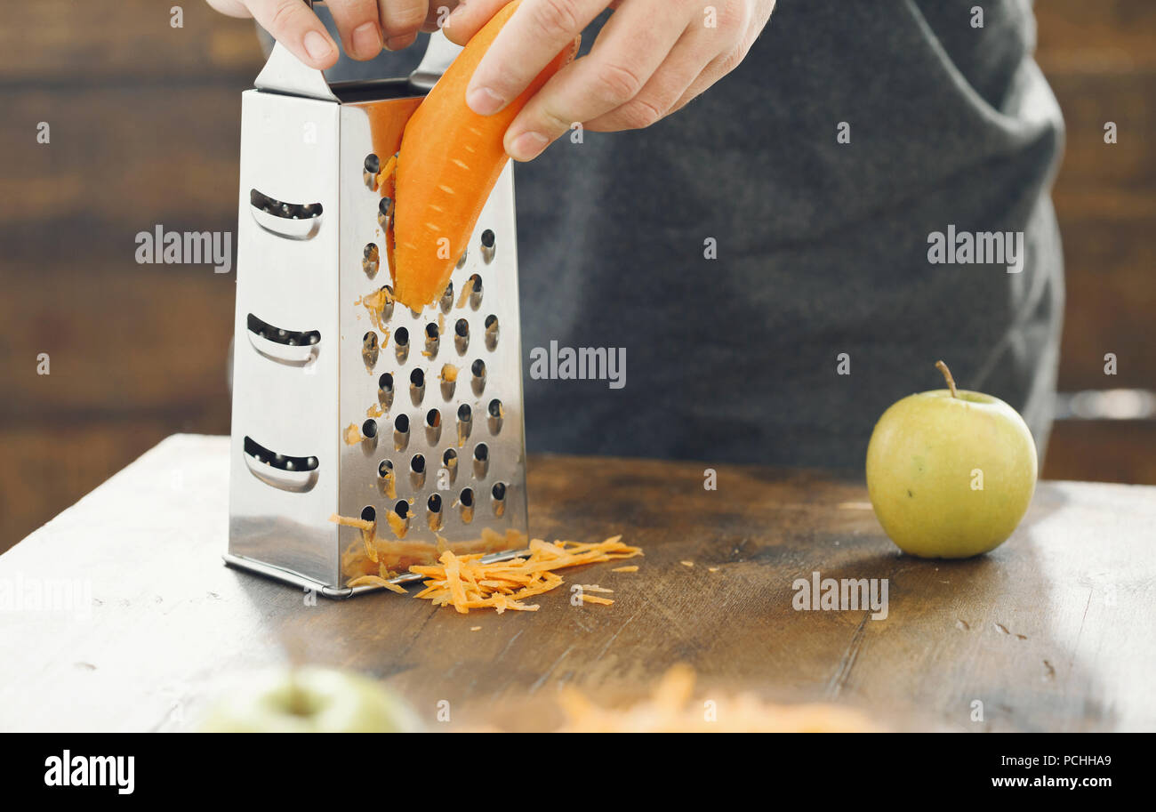 L'uomo prepara la colazione da Insalata di carote con mele. Cibo sano concetto Foto Stock