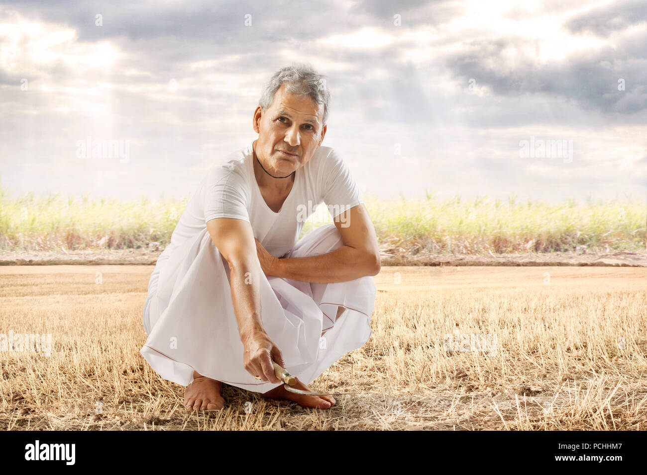 Indian senior agricoltore lavora nel suo campo a livello di azienda Foto Stock