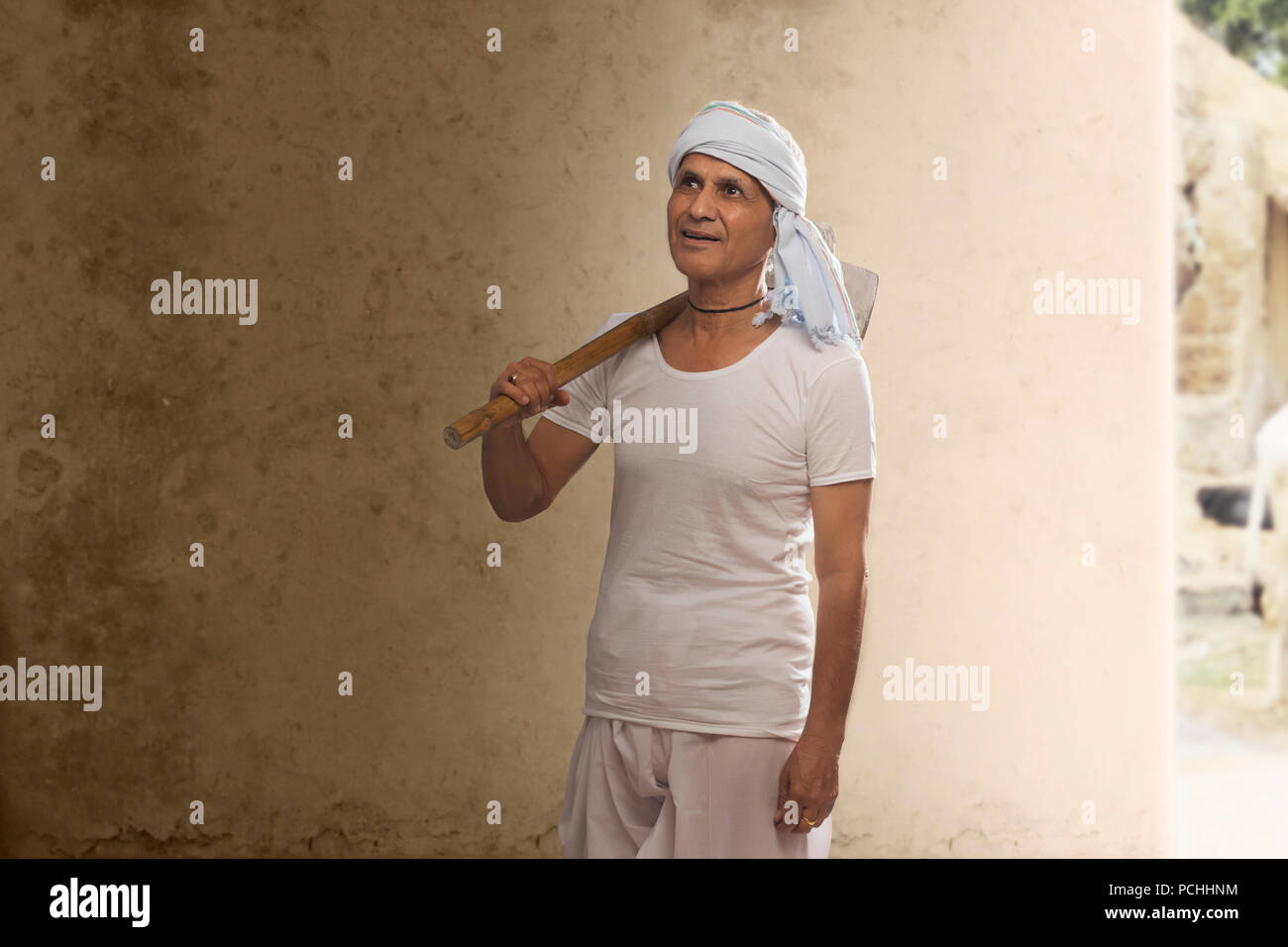 Ritratto di Indian vecchio contadino zappa portante sulla sua spalla Foto Stock