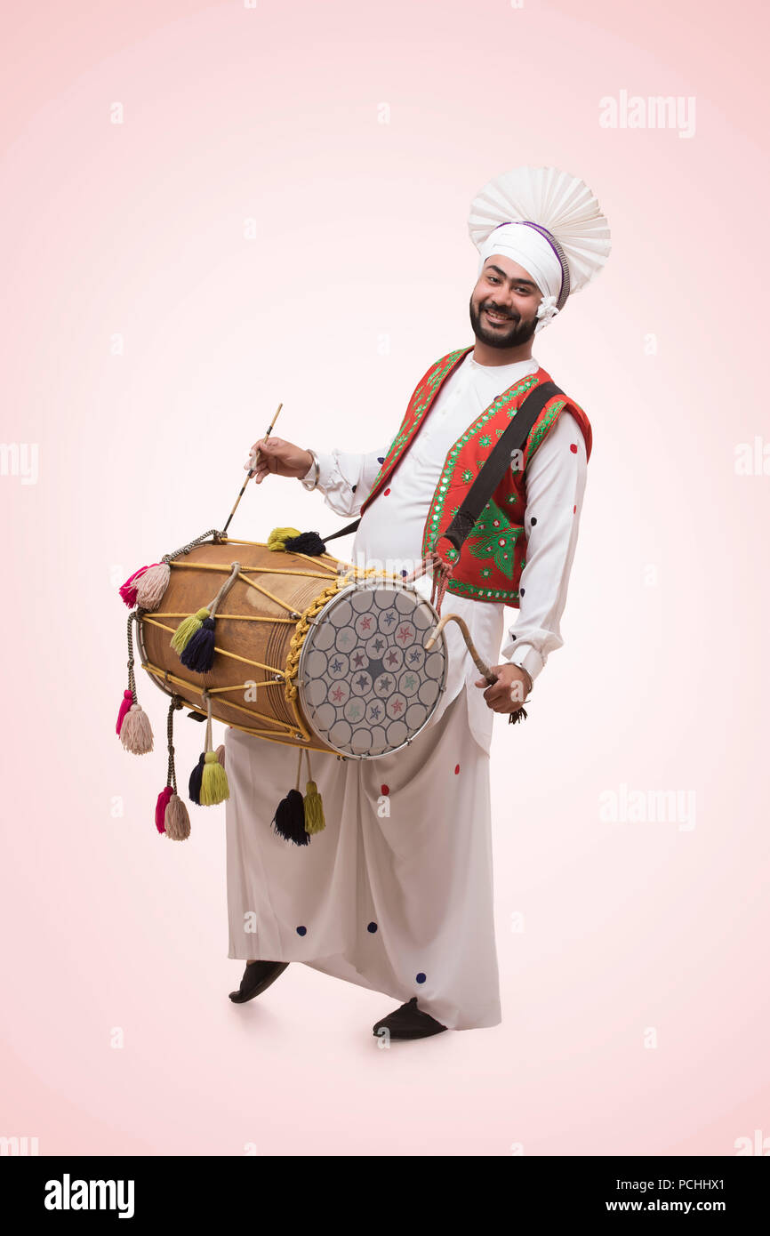 La religione sikh uomo giocando su un Dhol Foto Stock