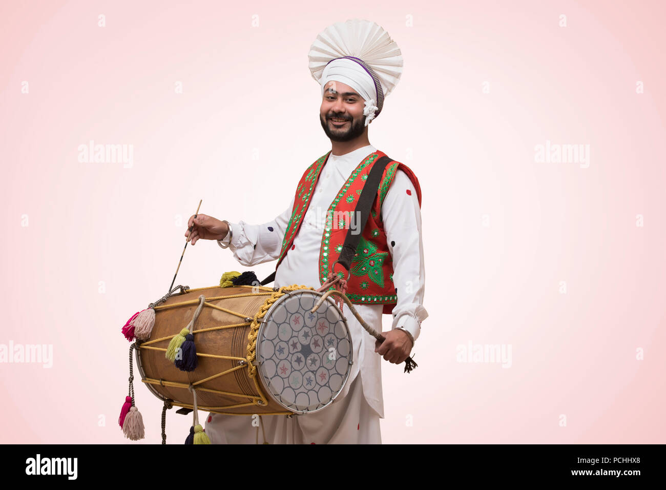 La religione sikh uomo giocando su un Dhol Foto Stock