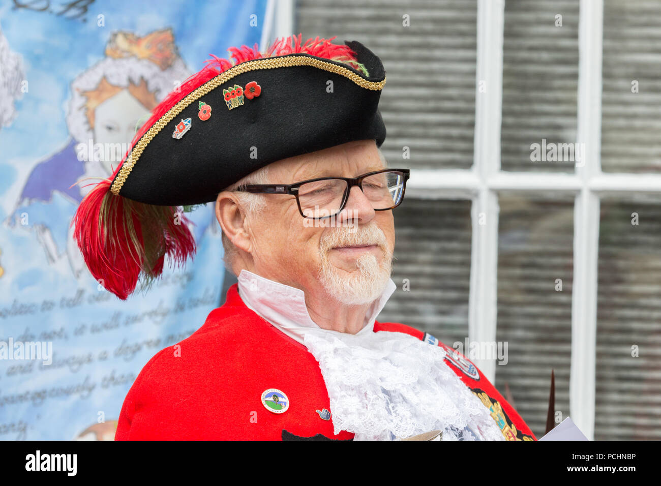 Il Kendal Town Crier annunciando notizie sul giorno di mercato nel mercato pennini città. Foto Stock