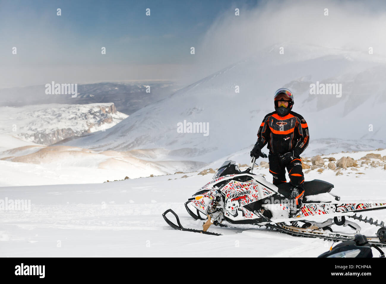 Uomo che pongono in piena marcia in piedi su una motoslitta BRP freeride. Russia, Adygea, altopiano Lago-Naki Febbraio 3, 2012. Foto Stock