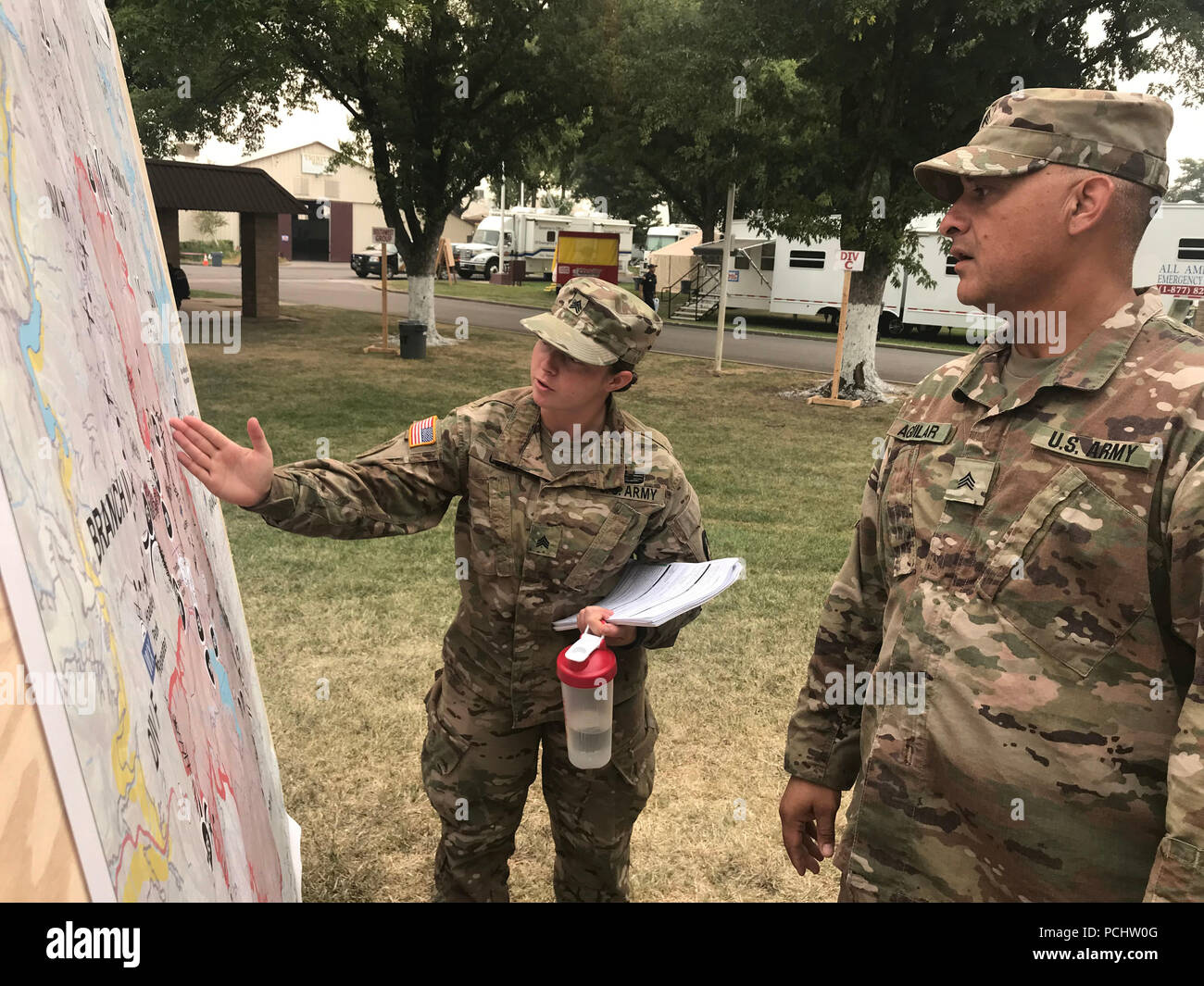 Stati Uniti Esercito Sgts. Nicole Coyle e Rudy Aguilar dell'Ingegnere 649th Company, ingegnere 579th battaglione, 49th Polizia Militare brigata, California Army National Guard, utilizzare una mappa di staging per coordinare il movimento di truppa 30 Luglio presso il quartiere di Shasta Fairgrounds, Anderson, California, durante il fuoco di Carr. (U.S. Esercito nazionale Guard photo by Staff Sgt. Eddie Siguenza.) Foto Stock