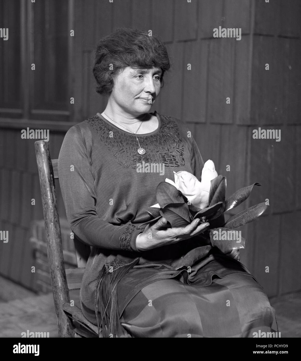 Helen Keller, ritratto seduto con grande fiore di magnolia nel 1920 a Los Angeles, California. Helen Keller (Giugno 27, 1880 - Giugno 1, 1968) era un autore americano, attivista politico, e docente. Lei è stato il primo sordo-persona cieca per guadagnare un bachelor del grado di arti. Foto Stock