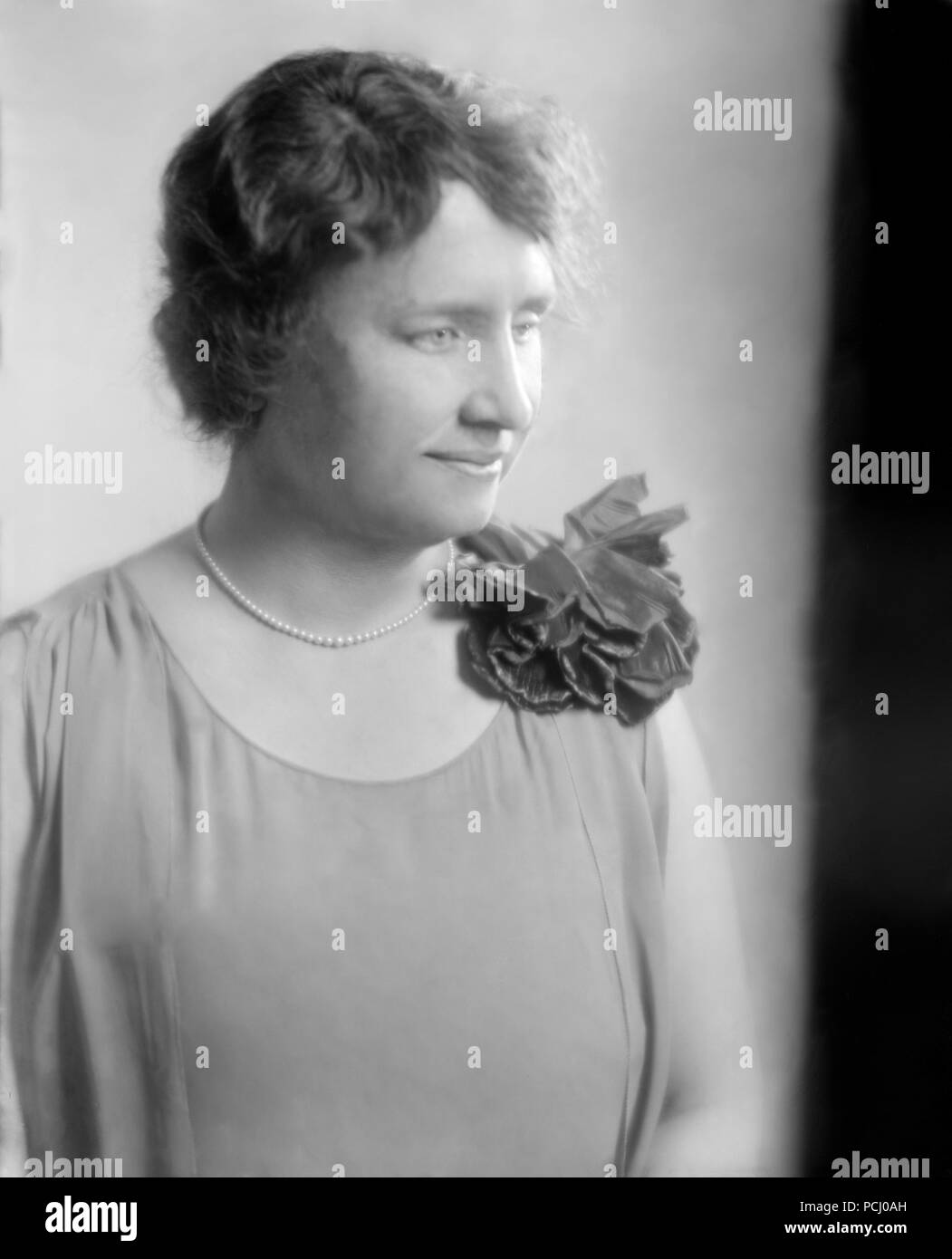Helen Keller, seduti indossando un fiore e guardando a destra in un ritratto non datata. Helen Keller (Giugno 27, 1880 - Giugno 1, 1968) era un autore americano, attivista politico, e docente. Lei è stato il primo sordo-persona cieca per guadagnare un bachelor del grado di arti. Foto Stock