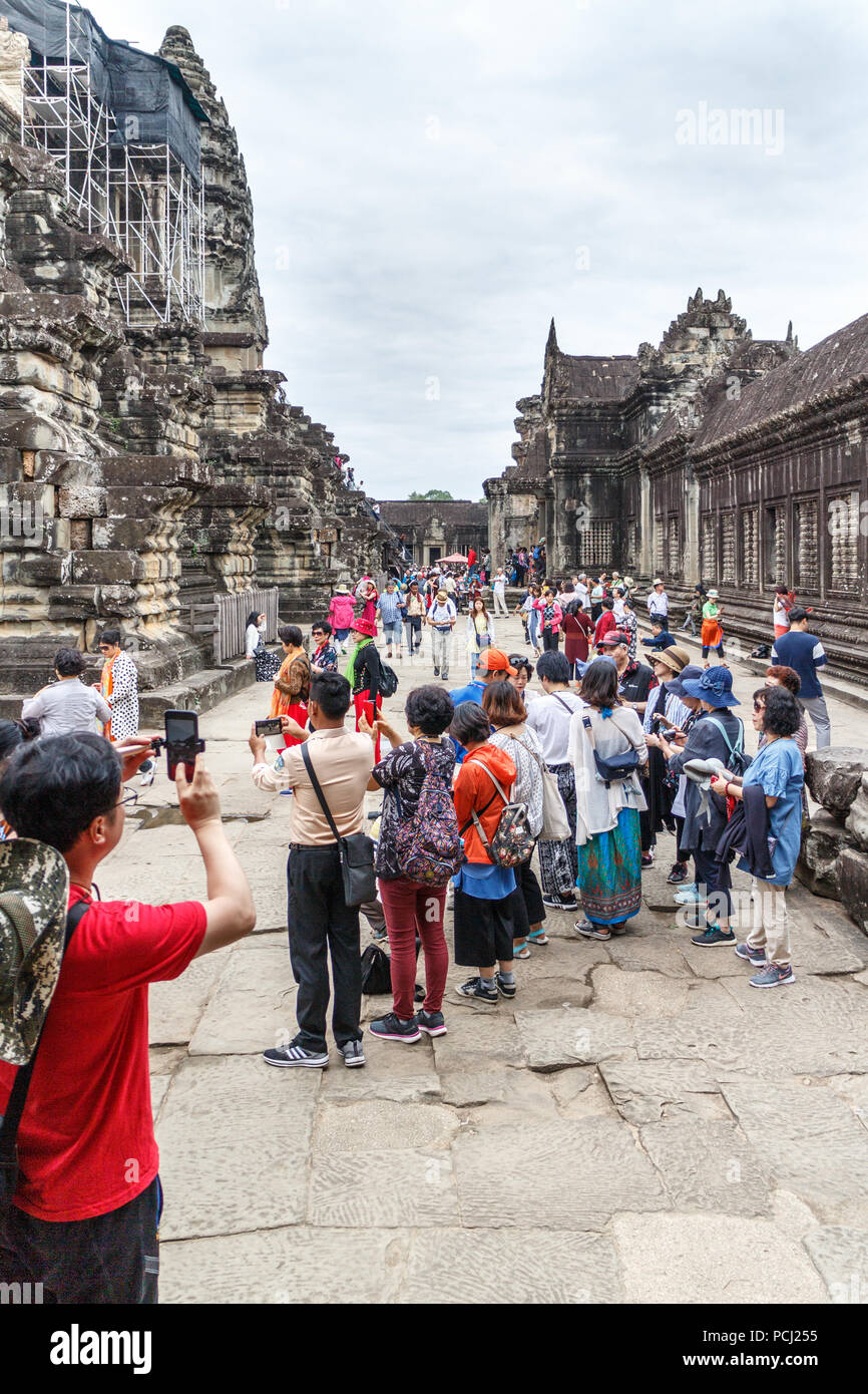 Angkor Wat, Cambogia - 11 Gennaio 2018: turisti cinesi rappresentano per le foto, i numeri enormi di visitare il tempio complesso Foto Stock