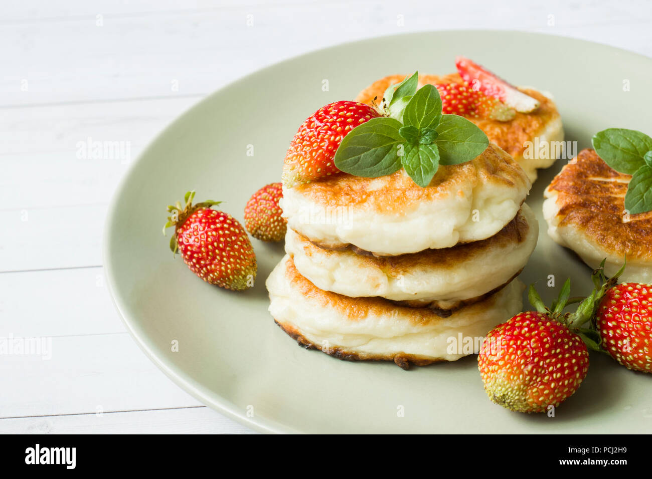 Cagliata pancake con fragole e menta su una piastra Foto Stock