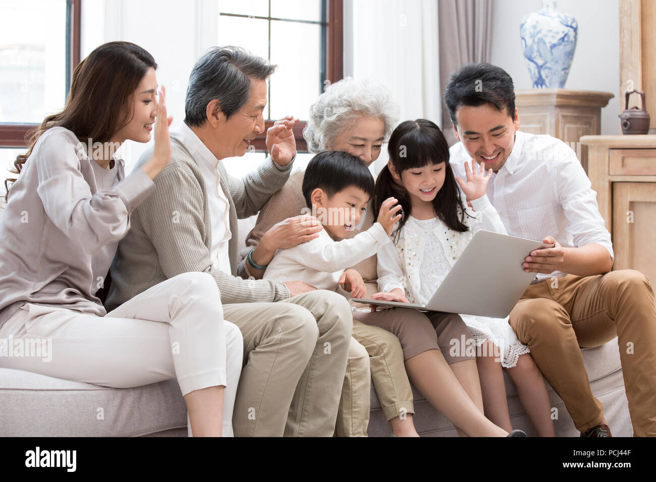 Felice famiglia cinese utilizzando laptop per le chat video Foto Stock