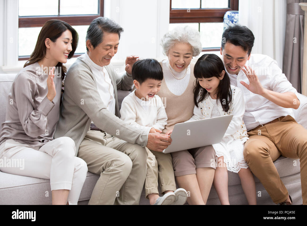 Felice famiglia cinese utilizzando laptop per le chat video Foto Stock