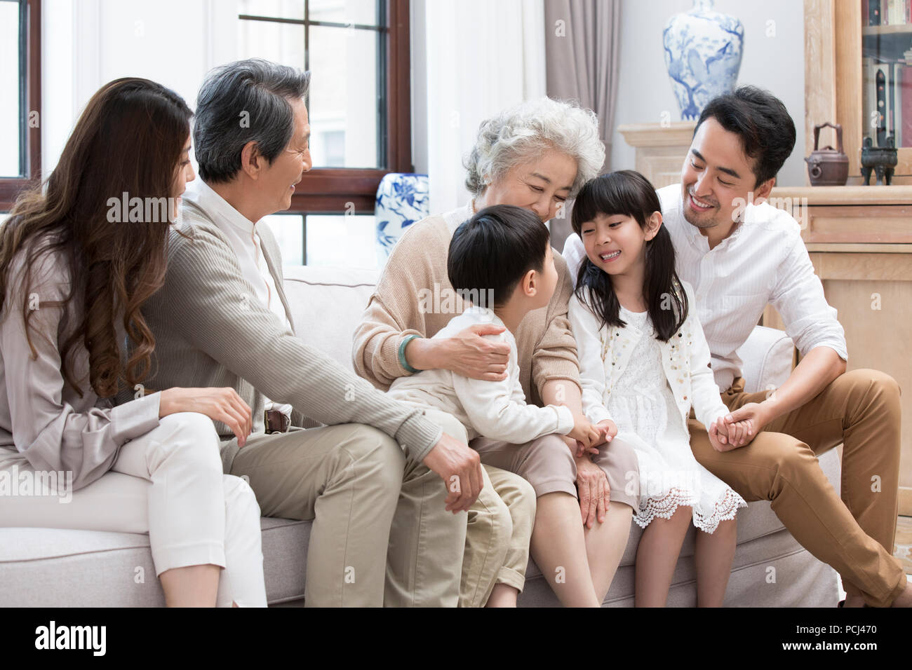 Felice famiglia cinese seduto sul divano Foto Stock