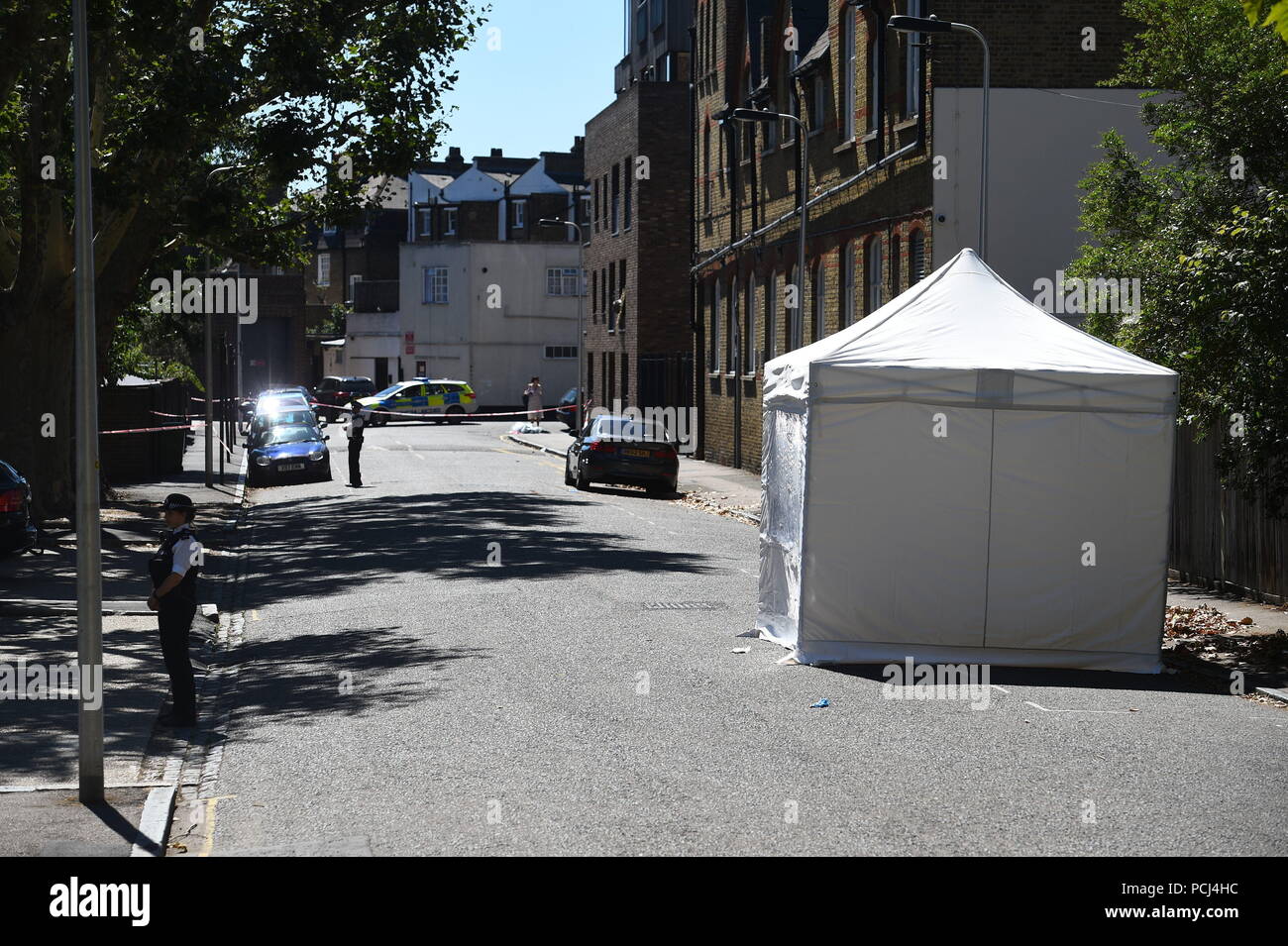La polizia di guardia a forensic tenda in Warham Street a Camberwell, Londra Sud, dove Mosca17 rapper incognito, il cui vero nome è creduto di essere Siddique Kamara, è stato ucciso e altri due feriti in un accoltellato. Foto Stock