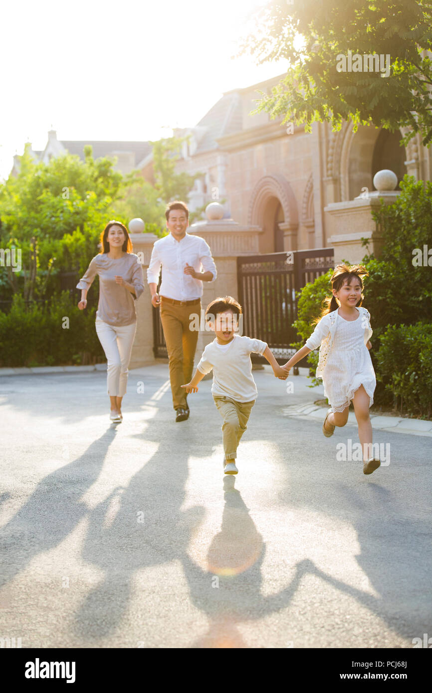 Felice giovane famiglia cinese a giocare al di fuori Foto Stock