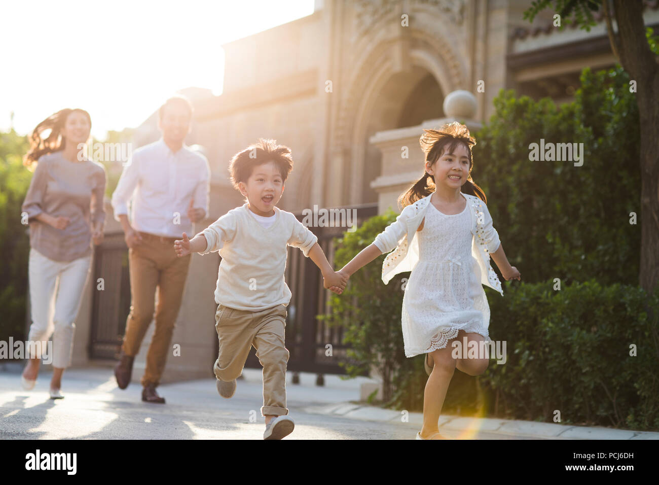 Felice giovane famiglia cinese a giocare al di fuori Foto Stock