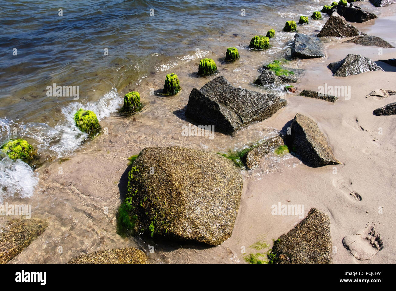 Germania Loddin,Stubbenfelde spiaggia.di balneazione costiere resort sull'isola di Usedom sul Mar Baltico. Rocks & legno groyne prevenire erosione della spiaggia sabbiosa Foto Stock
