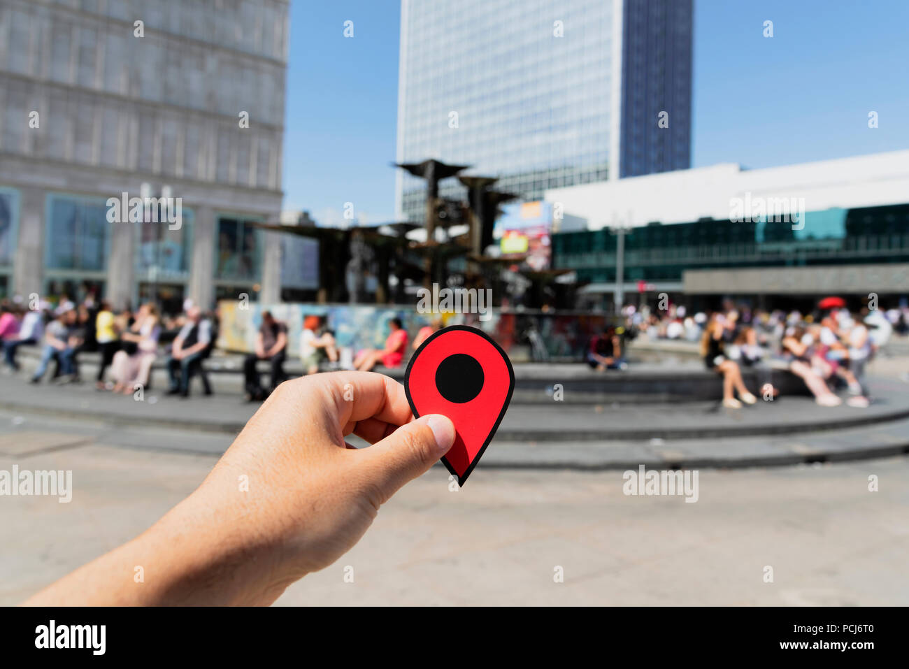 Primo piano della mano di un giovane uomo caucasico con un pennarello rosso alla famosa Alexanderplatz di Berlino, Germania Foto Stock